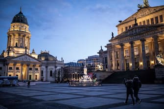1216256855 BERLIN, GERMANY - APRIL 01: A small amount of people walk near the empty square Gendarmenmarkt during the coronavirus crisis on April 01, 2020 in Berlin, Germany. The coronavirus and the disease it causes, Covid-19, are having a fundamental impact on society, government and the economy in Germany. Public life has been restricted to the essentials in an effort by authorities to slow the spread of infections. Hospitals are scrambling to increase their testing and care capacity. An economic recession seems likely as economic activity is slowed and many businesses are temporarily closed. Schools, daycare centers and universities remain shuttered. And government, both federal and state, seek to mobilize resources and find adequate policies to confront the virus and mitigate its impact. (Photo by Maja Hitij/Getty Images)