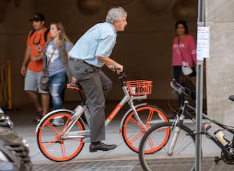 A man rides a Mobike throught the streets of Washington, DC, on September 20, 2017, after about 200 of the bicycles that are rented via an app that finds the closest bicycle via GPS became available for public use.
Chinese bike-sharing giant Mobike on Wednesday launched in the US capital, bringing its "dockless" system which has swept China and is used in some 180 cities worldwide. / AFP PHOTO / PAUL J. RICHARDS        (Photo credit should read PAUL J. RICHARDS/AFP via Getty Images)