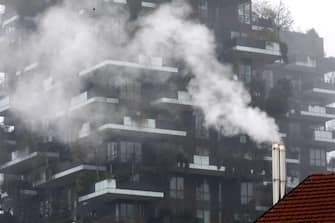 Una canna fumaria in zona Porta Nuova sullo sfondo il Bosco Verticale, Milano, 8 gennaio 20120.  In citta' restano ancora attive le misure anti inquinamento adottate in seguito all'aumento dei livelli di Pm10. 
ANSA / MATTEO BAZZI