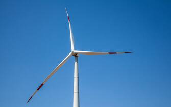 Wind turbine for electricity generation, renewable energy on a blue sky background. Copy space for text