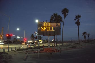 HUNTINGTON BEACH, CALIFORNIA - OCTOBER 03: A warning sign is posted near oil washed up on Huntington State Beach after a 126,000-gallon oil spill from an offshore oil platform on October 3, 2021 in Huntington Beach, California. The spill forced the closure of the popular Great Pacific Airshow with authorities urging people to avoid beaches in the vicinity. (Photo by Sefa Degirmenci/Anadolu Agency via Getty Images)