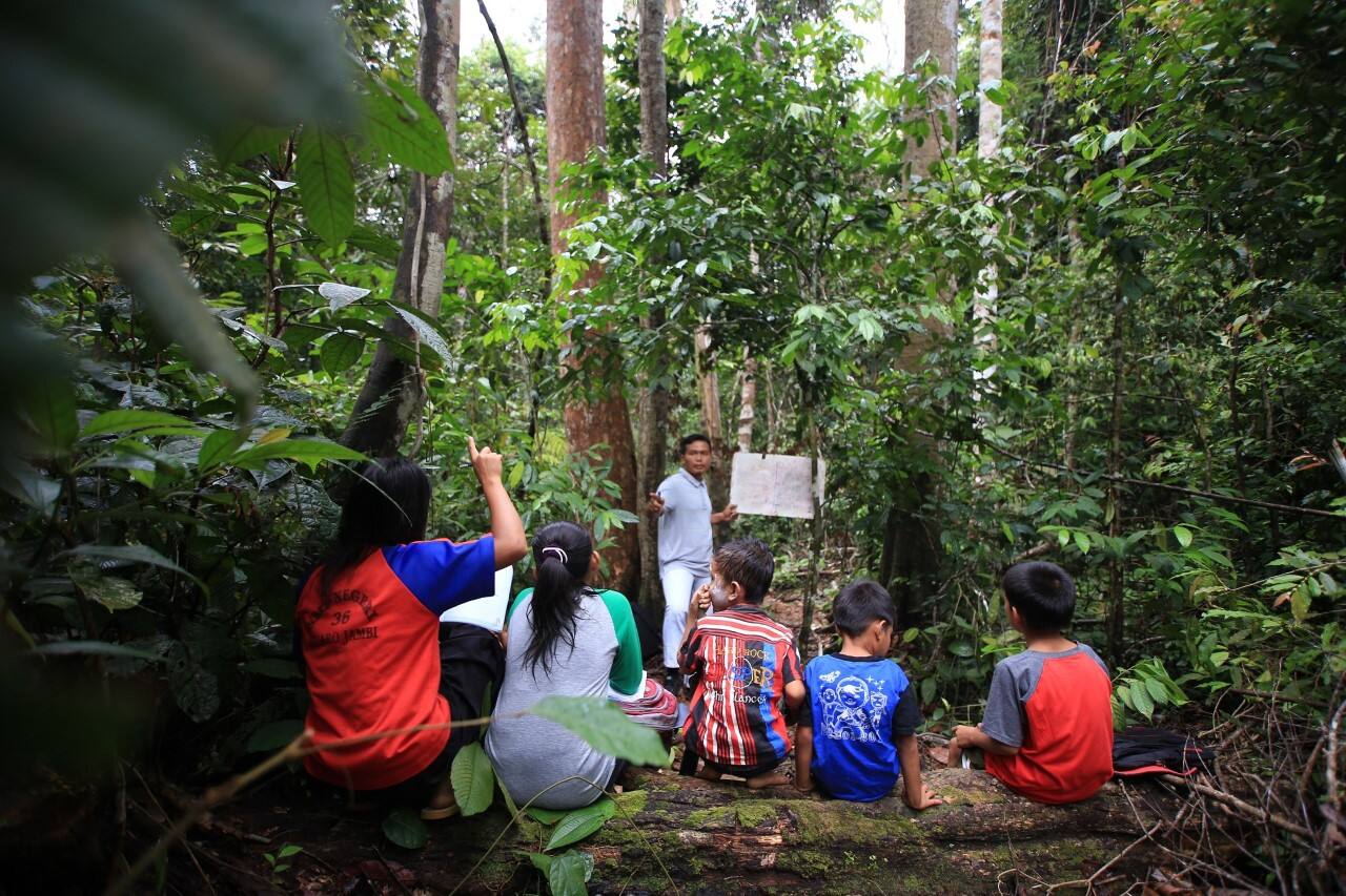 Insegnante insieme a bambini nella foresta di Hutan Harapan