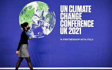 A participant walks past a COP26 UN Climate Change Conference' poster on the first day of the COP26 UN Climate Change Conference at the Scottish Event Campus (SEC) in Glasgow, Scotland, on October 31, 2021. - COP26, running from October 31 to November 12 in Glasgow will be the biggest climate conference since the 2015 Paris summit and is seen as crucial in setting worldwide emission targets to slow global warming, as well as firming up other key commitments. (Photo by ALAIN JOCARD / AFP) (Photo by ALAIN JOCARD/AFP via Getty Images)