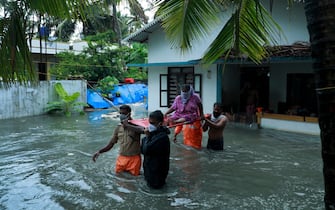 Police and rescue personnel evacuate local residents from a flooded house in a coastal area after heavy rains under the influence of cyclone 'Tauktae' in Kochi on May 14, 2021. (Photo by Arunchandra BOSE / AFP) (Photo by ARUNCHANDRA BOSE/AFP via Getty Images)
