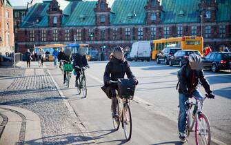 Cyclists use a cycle lane to travel past the Copenhagen Stock Exchange, center, in Copenhagen, Denmark, on Tuesday, March 13, 2012. Denmark's $460 billion mortgage bond system is too reliant on quarterly auctions to refinance about two thirds of its debt, and needs to do more to distribute the risk over the whole year, the central bank warned. Photographer: Ulrik Jantzen/Bloomberg
