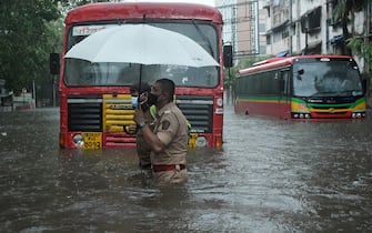 May 17, 2021, Mumbai, India: A policeman helps a public transport driver to cross a flooded street due to heavy rain caused by Cyclone Tauktae in Mumbai. Strong winds and heavy rain lashed Mumbai and its neighboring areas today morning due to a severe cyclonic storm. It made landfall near the Gujarat coast. (Credit Image: © Ashish Vaishnav/SOPA Images via ZUMA Wire)