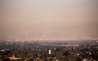 epa09498824 Downtown Los Angeles can be barely seen covered with smog from pollution and particles from the numerous fires burning in California, in Signal Hill, California, USA, 30 September 2021. Wildfires' heavy smoke pushing South has triggered special air quality advisory from the South Coast Air Quality Management District.  EPA/ETIENNE LAURENT