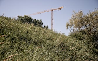 1404830335 SALERNO, ITALY - JUNE 19: A construction crane is seen in a rural area near the city on June 19, 2022 in Salerno, Italy. In Italy, the latest ISPRA report published in July 2021, denounces the continuous loss of soil in a country that has various emergencies including: hydrogeological risks, desertification risk, loss of water resources, increase in average temperatures in cities due to continuous overbuilding. (Photo by Ivan Romano/Getty Images)