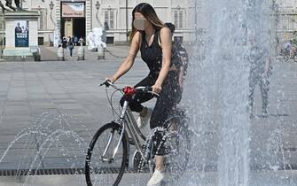 METEO: CALDO TORRIDO E SICCITA' Persone cercano refigerio nelle fontane e nei giardini per il caldo torrido e fiume po in secca a Torino, 16 giugno 2022 ANSA/ALESSANDRO DI MARCO