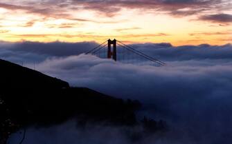 SAUSALITO, CA - OCTOBER 8:  The north tower of the Golden Gate Bridge is blanketed by fog as the sun rises October 8, 2007 in Sausalito, California. Temperatures around the San Francisco Bay and coast are expected to be in the 50's to 60's under partly cloudy skies October 8. (Photo by Justin Sullivan/Getty Images)
