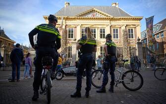 epa10269112 Police officers stand outside the Mauritshuis museum, where three people were arrested for attempting to smudge Vermeer's painting 'Girl with a Pearl Earring', currently exhibited there, in The Hague, Netherlands, 27 October 2022. They were wearing shirts from the Just Stop Oil campaign group, whose members are responsible for recent acts of vandalism - such as throwing soup at paintings, sports cars and luxury shop windows across Europe - in an attempt to raise awareness about their protest against fossil fuels.  EPA/PHIL NIJHUIS