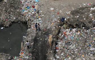 epa10671132 Indian people walk near the plastic waste dumped inside a drain in Taimoor Nagar in New Delhi, India, 25 May 2023. (Issued 03 May 2023). According to the report issued Swachh Bharat Mission (Urban) Plastic Waste Management Solutions and Case Studies, government of India, It is estimated that approximately 70% of plastic packaging products are converted into plastic waste in a short span. The world will mark Environment Day on 05 June 2023 and it will focus on solutions to plastic pollution.  EPA/RAJAT GUPTA  ATTENTION: This Image is part of a PHOTO SET