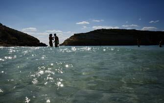 Tourists bathe on the beach of the Isola dei Conigli (Rabbit Island) in Lampedusa on September 27, 2018. - Five years after the worst shipwreck of its history, the Italian Pelagie island of Lampedusa relies on the flood of tourists to make a fresh start, though it might become a gateway to Europe again. (Photo by Alberto PIZZOLI / AFP) / TO GO WITH AFP STORY BY FANNY CARRIER        (Photo credit should read ALBERTO PIZZOLI/AFP via Getty Images)