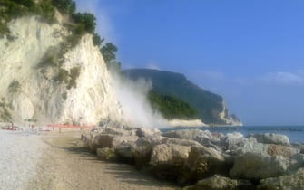 Handout image released by Italian port captaincy on 22 August 2013 shows the smoke raised by the collapse of a limestone block that broke off from the Monte Conero, falling between the beach and the Lavi Lilies of Ancona, in coincidence of the 4.4 earthquake in the Marches, 22 August 2013.  ANSA/ UFFICIO STAMPA CAPITANERIA PORTO ANCONA ++HO - NO SALES EDITORIAL US EONLY++