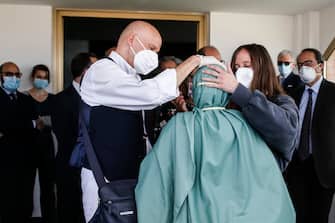 La cooperante Silvia Romano, vestita con una tunica verde, salutata dal padre Enzo e dalla sorella al suo arrivo all'aeroporto di Caimpino, Roma. 10 maggio 2020. ANSA / FABIO FRUSTACI
