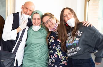 Italian cooperator, Silvia Romano (R), wearing a green tunic, is welcomed by her mother Francesca Fumagalli, her father Enzo and her sister upon her arrival at the Ciampino airport, Rome, Italy, 10 May 2020. Silvia Romano was kidnapped on Novembre 2018 in Kenya. ANSA/FABIO FRUSTACI