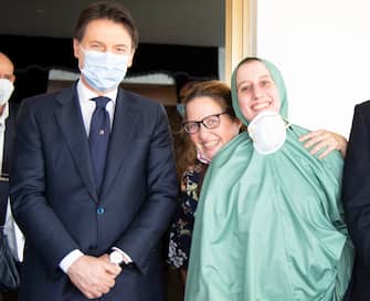 Italian cooperator, Silvia Romano (R), wearing a green tunic, is welcomed by the italian prime minister Giuseppe Conte (L) and her mother Francesca Fumagalli upon her arrival at the Ciampino airport, Rome, Italy, 10 May 2020. Silvia Romano was kidnapped on Novembre 2018 in Kenya. ANSA/FABIO FRUSTACI