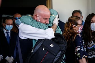 A handout photo made available by the Chigi Palace (Palazzo Chigi) Press Office shows italian cooperator, Silvia Romano, wearing a green tunic, hugging her family upne her arrivla at the Ciampino airport, Rome, Italy, 10 May 2020. Silvia Romano was kidnapped on Novembre 2018 in Kenya. Ansa/ Chigi Palace Press Office 
+++ ANSA PROVIDES ACCESS TO THIS HANDOUT PHOTO TO BE USED SOLELY TO ILLUSTRATE NEWS REPORTING OR COMMENTARY ON THE FACTS OR EVENTS DEPICTED IN THIS IMAGE; NO ARCHIVING; NO LICENSING +++