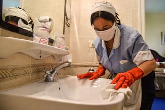 An employee of the Cuban National Hotel cleans and disinfect the bathroom of a room occupied by tourists, as a preventive measure in the face of the global COVID-19 coronavirus pandemic, in Havana on March 14, 2020. (Photo by STR / AFP) (Photo by STR/AFP via Getty Images)