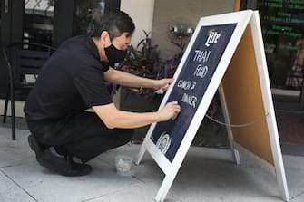 PALM BEACH, FLORIDA - MAY 11: Gary Tharitimanont uses a chalk board to let patrons know his Peppermint Downtown Thai restaurant is open on May 11, 2020 in Palm Beach, Florida. The restaueant opened as Palm Beach County, starts the first phase of the states coronavirus pandemic reopening plan, which includes  openings of businesses, with certain caveats, like barbershops, restaurants and retail stores. (Photo by Joe Raedle/Getty Images)