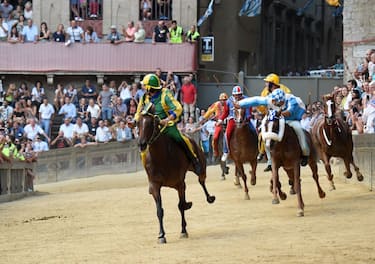 Rider Andrea Mari known as Brio on Bruco Contrada team horse Schietta (L) rides ahead of Carlo Sanna known as Brigante on Onda team horse Porto Alabe during the historical Italian horse race "Palio di Siena" on August 16, 2019 in Siena. (Photo by Filippo MONTEFORTE / AFP)        (Photo credit should read FILIPPO MONTEFORTE/AFP via Getty Images)