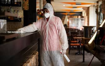 MILAN, ITALY - MAY 15:  A worker wearing personal protective equipment (PPE) cleans the Maya pub near the Navigli for the reopening during the COVID-19 panddemic on May 15, 2020 in Milan, Italy. Italy was the first country to impose a nationwide lockdown to stem the transmission of the Coronavirus (Covid-19), and its restaurants, theaters and many other businesses remain closed. (Photo by Lorenzo Palizzolo/Getty Images)