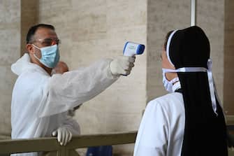 A nun undergoes body temperature scanning while going through security to access St. Peter's Square and Basilica on May 18, 2020 in The Vatican during the lockdown aimed at curbing the spread of the COVID-19 infection, caused by the novel coronavirus. - Saint Peter's Basilica throws its doors open to visitors on May 18, 2020, marking a relative return to normality at the Vatican and beyond in Italy, where most business activity is set to resume. (Photo by Vincenzo PINTO / AFP) (Photo by VINCENZO PINTO/AFP via Getty Images)