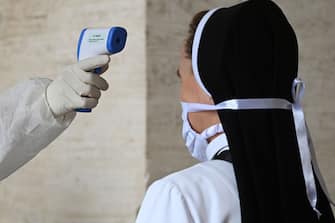 A nun undergoes body temperature scanning while going through security to access St. Peter's Square and Basilica on May 18, 2020 in The Vatican during the lockdown aimed at curbing the spread of the COVID-19 infection, caused by the novel coronavirus. - Saint Peter's Basilica throws its doors open to visitors on May 18, 2020, marking a relative return to normality at the Vatican and beyond in Italy, where most business activity is set to resume. (Photo by Vincenzo PINTO / AFP) (Photo by VINCENZO PINTO/AFP via Getty Images)