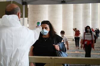 A woman undergoes body temperature scanning while going through security to access St. Peter's Square and Basilica on May 18, 2020 in The Vatican during the lockdown aimed at curbing the spread of the COVID-19 infection, caused by the novel coronavirus. - Saint Peter's Basilica throws its doors open to visitors on May 18, 2020, marking a relative return to normality at the Vatican and beyond in Italy, where most business activity is set to resume. (Photo by Vincenzo PINTO / AFP) (Photo by VINCENZO PINTO/AFP via Getty Images)