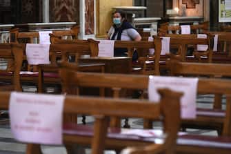 A woman attends mass at the church of Santa Maria in Traspontina in Rome on May 18, 2020 during the country's lockdown aimed at curbing the spread of the COVID-19 infection, caused by the novel coronavirus. - Restaurants and churches reopen in Italy on May 18, 2020 as part of a fresh wave of lockdown easing in Europe and the country's latest step in a cautious, gradual return to normality, allowing businesses and churches to reopen after a two-month lockdown. Placards read "Security distancing, do not seat in this space". (Photo by Vincenzo PINTO / AFP) (Photo by VINCENZO PINTO/AFP via Getty Images)