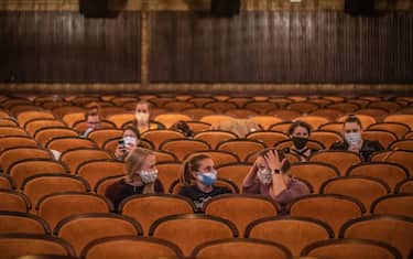 epa08415463 People wearing protective face masks wait for screening as they sit in a reopened cinema in the centre of Prague, Czech Republic, 11 May 2020. Cinemas across the country are allowed to play again with maximum attendance of 100 people from 11 May 2020 as next wave of Czech government's easing the restrictive measures declared to quell the spread of the pandemic COVID-19 disease caused by the SARS-CoV-2 coronavirus.  EPA/MARTIN DIVISEK