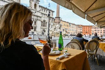 A woman drinks wine and has lunch at a restaurant's terrace on Piazza Navona in central Rome on May 18, 2020 during the country's lockdown aimed at curbing the spread of the COVID-19 infection, caused by the novel coronavirus. - Restaurants and churches reopen in Italy on May 18, 2020 as part of a fresh wave of lockdown easing in Europe and the country's latest step in a cautious, gradual return to normality, allowing businesses and churches to reopen after a two-month lockdown. (Photo by ANDREAS SOLARO / AFP) (Photo by ANDREAS SOLARO/AFP via Getty Images)