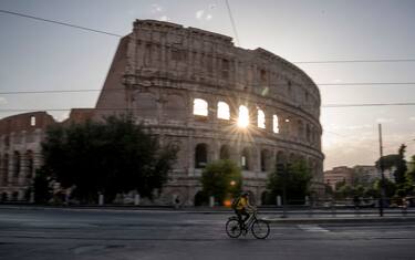 ROME, ITALY - MAY 18: A man wearing protective mask rides a bike near Colosseo (Colosseum) area after two months of closure, during Italy's phase two coronavirus (Covid-19) lockdown exit plan, on May 18, 2020 in Rome, Italy. Churches, restaurants, bars, cafes, hairdressers and other shops have reopened, subject to social distancing measures, after more than two months of a nationwide lockdown meant to curb the spread of Covid-19. (Photo by Antonio Masiello/Getty Images)