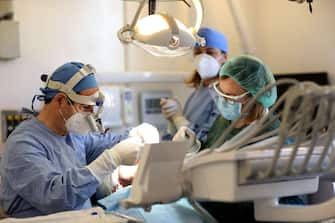ROME, ITALY - MAY 21: Dentist Priamo Mura and his assistants Gianna and Natalia, wearing personal protective equipment (PPE / EPI), treat a patient at 'Studio Mura' on May 21, 2020 in Rome, Italy. Restaurants, bars, cafes, hairdressers and other shops have reopened, subject to social distancing measures, after more than two months of a nationwide lockdown meant to curb the spread of Covid-19. (Photo by Franco Origlia/Getty Images)