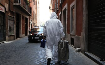 ROME, ITALY - MAY 15: A technician who has just sanitized a shop in central Rome walks down an alley at the end of his job on May 15, 2020 in Rome, Italy.  Italy was the first country to impose a nationwide lockdown to stem the transmission of the Coronavirus (Covid-19) and it has started to ease these restrictions in recent weeks. The initial reopening date decided by the government would have been June 1, but due to pressure from the regional governments, trade associations and the public, this process has been accelerated. However, many businesses have complained that the government has not provided complete safety guidelines for the various types of businesses permitted to reopen and, consequently, some have decided to postpone their opening. (Photo by Marco Di Lauro/Getty Images)