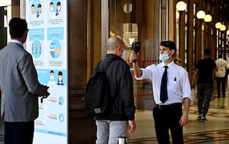 A man (C) undergoes a body temperature scan as he enters the Alberto-Sordi shopping gallery on Via del Corso on May 20, 2020 in central Rome, as the country's is easing its lockdown aimed at curbing the spread of the COVID-19 infection, caused by the novel coronavirus. (Photo by Vincenzo PINTO / AFP) (Photo by VINCENZO PINTO/AFP via Getty Images)
