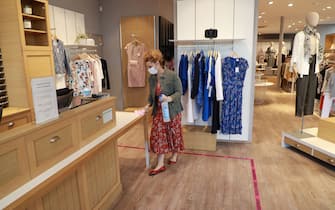 1212769008 A worker disinfect parts of a clothes store before opening to customers in Paris on May 12, 2020, on the second day after France eased lockdown measures taken to curb the spread of the COVID-19 pandemic, caused by the new coronavirus. (Photo by Ludovic MARIN / AFP) (Photo by LUDOVIC MARIN/AFP via Getty Images)