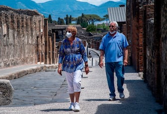 US couple from Detroit, Marvin and Colleen Hewson, who spent the lockdown since March 7 in a nearby Bed and Breakfast, visit the archeological site of Pompeii on May 26, 2020, as the country eases its lockdown aimed at curbing the spread of the COVID-19 infection, caused by the novel coronavirus. - Italy's world-famous archeological site Pompeii reopened to the public on May 26,bBut with foreign tourists still prohibited from travel to Italy until June, the site that attracted just under 4 million visitors in 2019 is hoping that for now, Italian tourists can make up at least a fraction of the difference. (Photo by Tiziana FABI / AFP) (Photo by TIZIANA FABI/AFP via Getty Images)
