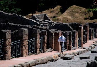 A man walks across the archeological site of Pompeii on May 26, 2020, as the country eases its lockdown aimed at curbing the spread of the COVID-19 infection, caused by the novel coronavirus. - Italy's world-famous archeological site Pompeii reopened to the public on May 26,bBut with foreign tourists still prohibited from travel to Italy until June, the site that attracted just under 4 million visitors in 2019 is hoping that for now, Italian tourists can make up at least a fraction of the difference. (Photo by Tiziana FABI / AFP) (Photo by TIZIANA FABI/AFP via Getty Images)