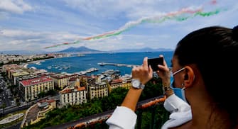 A woman wearing a protective face mask takes a picture as the aerobatic demonstration team 'Frecce Tricolori ' of the Italian Air Force, leaving green, white, and red smoke trails, flies in formation above the Gulf of Naples, southern Italy, 28 May 2020. Starting from 25 May 2020, the Frecce Tricolori are performing every day in the skies throughout Italy as part of the 74th anniversary celebrations of the founding of the Italian Republic and to pay homage to the areas most affected by the coronavirus disease (COVID-19) pandemic. The initiative will end on 02 June in Rome on the occasion of the Republic Day (Italian National Day).
ANSA/ CIRO FUSCO
