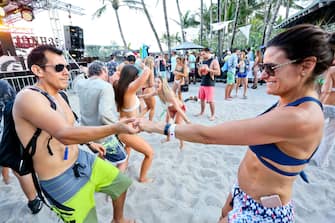 MIAMI BEACH, FLORIDA - MARCH 17: People dance to DJ music during the launch pool party produced by 93.5FM Revolution Radio Miami at the Nationl Hotel on South Beach as part of Miami Music  Week on March 17, 2018 in Miami Beach, Florida.  (Photo by Sean Drakes/Getty Images)