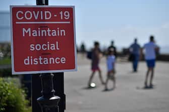 Signs advise beachgoers arriving at the seafront to 'Maintain Social Distance due to COVID-19", on the promenade in Southend-on-Sea, south east England on May 25, 2020, after lockdown restrictions, originally put in place due the COVID-19 pandemic, were lifted earlier this month. - British Prime Minister Boris Johnson on Sunday backed top aide Dominic Cummings despite mounting pressure from within his own party to sack him over claims he broke coronavirus lockdown regulations. (Photo by Ben STANSALL / AFP) (Photo by BEN STANSALL/AFP via Getty Images)
