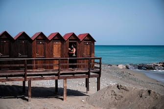 The owner of a bathing facility prepares beach cabins for the upcoming summer season, on May 14 2020 in Albissola Marina, near Savona, Liguria, during the country's lockdown aimed at curbing the spread of the COVID-19 infection, caused by the novel coronavirus. (Photo by MARCO BERTORELLO / AFP) (Photo by MARCO BERTORELLO/AFP via Getty Images)