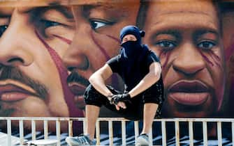 Italian street artist Jorit Agoch poses next to his latest work, a huge mural in memory of George Floyd, in Naples, southern Italy, 04 June 2020. Faces of Lenin, Martin Luther King, Malcom X and Angela Davis are also painted on the mural.
ANSA/ CIRO FUSCO