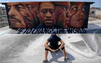 Italian street artist Jorit Agoch poses next to his latest work, a huge mural in memory of George Floyd, in Naples, southern Italy, 04 June 2020. Faces of Lenin, Martin Luther King, Malcom X and Angela Davis are also painted on the mural.
ANSA/ CIRO FUSCO