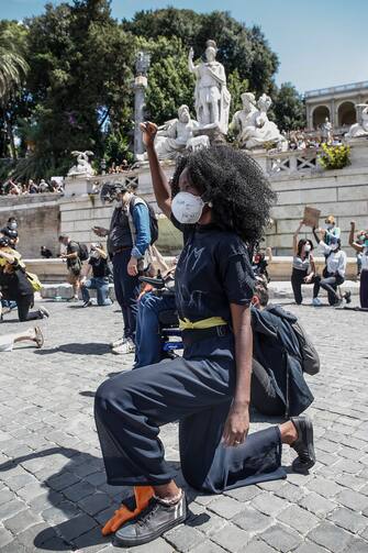 People are on their knees, with raised fist, as they attend a demonstration in memory of George Floyd in Piazza del Popolo, Rome, Italy, 07 June 2020. The protesters gather to demonstrate in the wake of the death in police custody of George Floyd in the United States. ANSA/ FABIO FRUSTACI