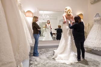 CATANIA, ITALY - MAY 06: A customer tries a wedding dress in the atelier of designer Mariella Gennarino of Catania, open again to the public after the lockdown on May 6, 2020 in Catania, Italy. Italy will remain on lockdown to stem the transmission of the Coronavirus (Covid-19), slowly easing restrictions. (Photo by Fabrizio Villa/Getty Images)