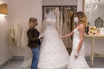 CATANIA, ITALY - MAY 06: A customer tries on a wedding dress in the atelier of designer Mariella Gennarino of Catania, open again to the public after the lockdown on May 6, 2020 in Catania, Italy. Italy will remain on lockdown to stem the transmission of the Coronavirus (Covid-19), slowly easing restrictions. (Photo by Fabrizio Villa/Getty Images)