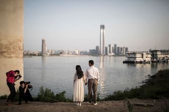 WUHAN, CHINA - APRIL 15:  The wedding photographer and assistant take photos for a couple at the Jiangtan park on April 15, 2020 in Wuhan, central China's Hubei Province. People in Wuhan have restarted wedding preparations as the coronavirus outbreak wanes. (Photo by Getty Images)