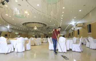 A Palestinian worker sweeps a wedding hall in Gaza City on June 3, 2020 following the easing of COVID-19 coronavirus restrictions. (Photo by MAHMUD HAMS / AFP) (Photo by MAHMUD HAMS/AFP via Getty Images)